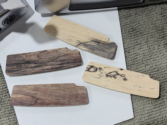 Four wooden inserts with unique grain patterns for a putter.