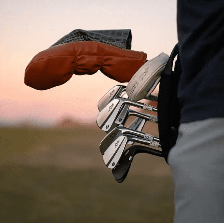 Golf clubs in a bag at sunset