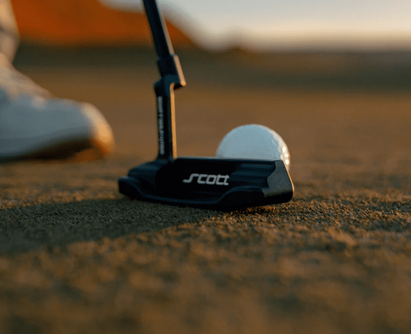 Golf ball near putter on course